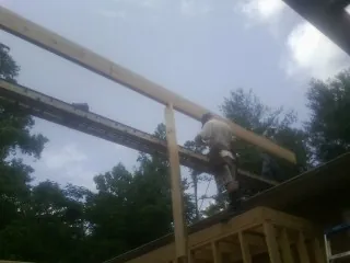 Carpenter setting a ridge beam over a new addition frame — Ice Dam Removal by Roofing Brothers in Rahway