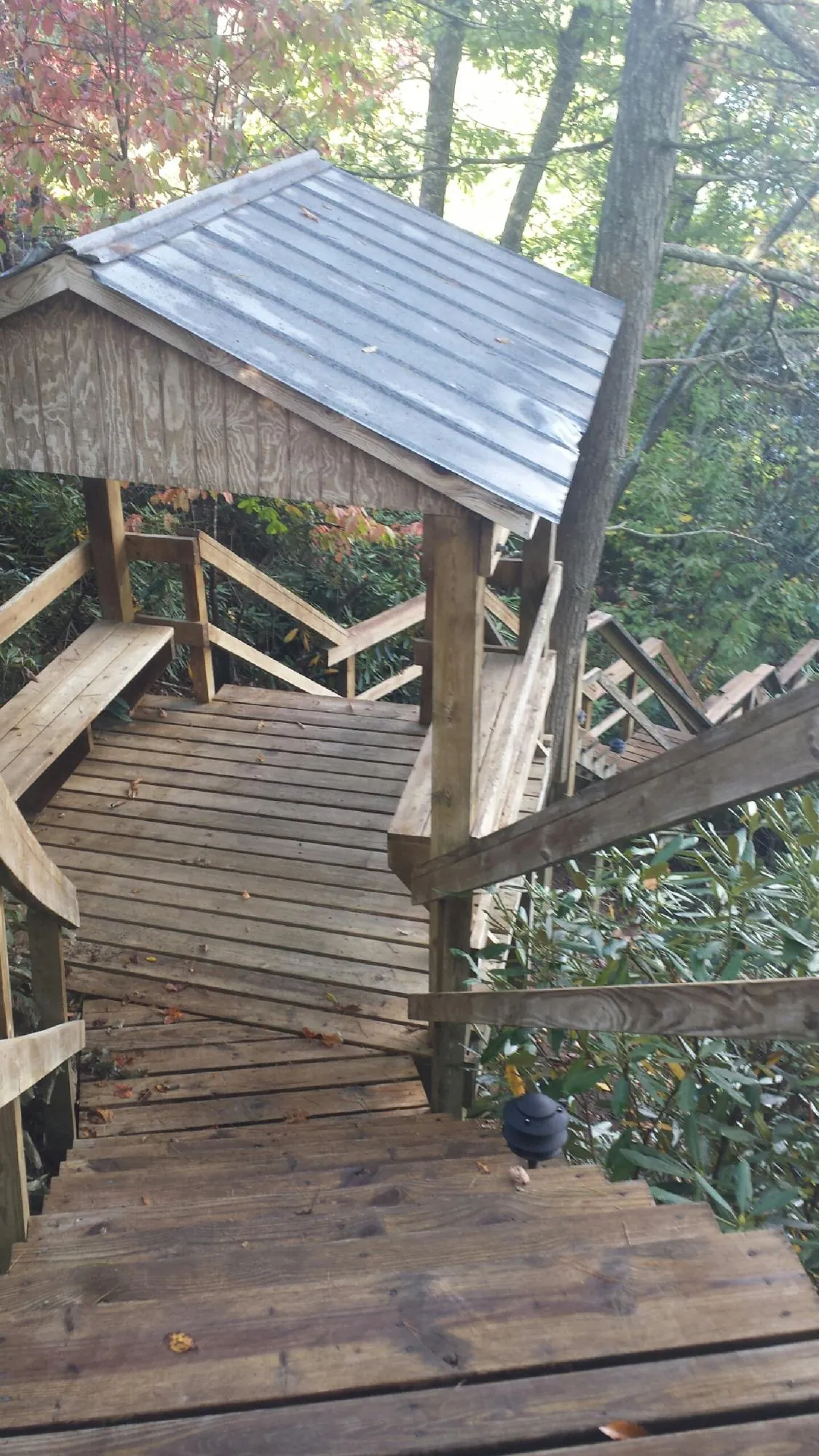 Metal roofed shelter over wooden steps on a wooded walkway — Skylight Repair & Installation work by our crew in Rahway